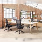 Two black Senator Ousby mesh chairs shown at a large workstation in a modern