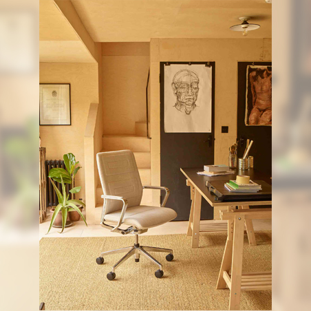 A beige upholstered Senator Qdos office chair with a chrome base, shown at a desk in a warm, wood-paneled home office