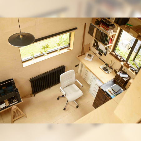 A high-angle view of a modern home office, with a light grey Senator Qdos High Back Chair positioned at a wooden desk